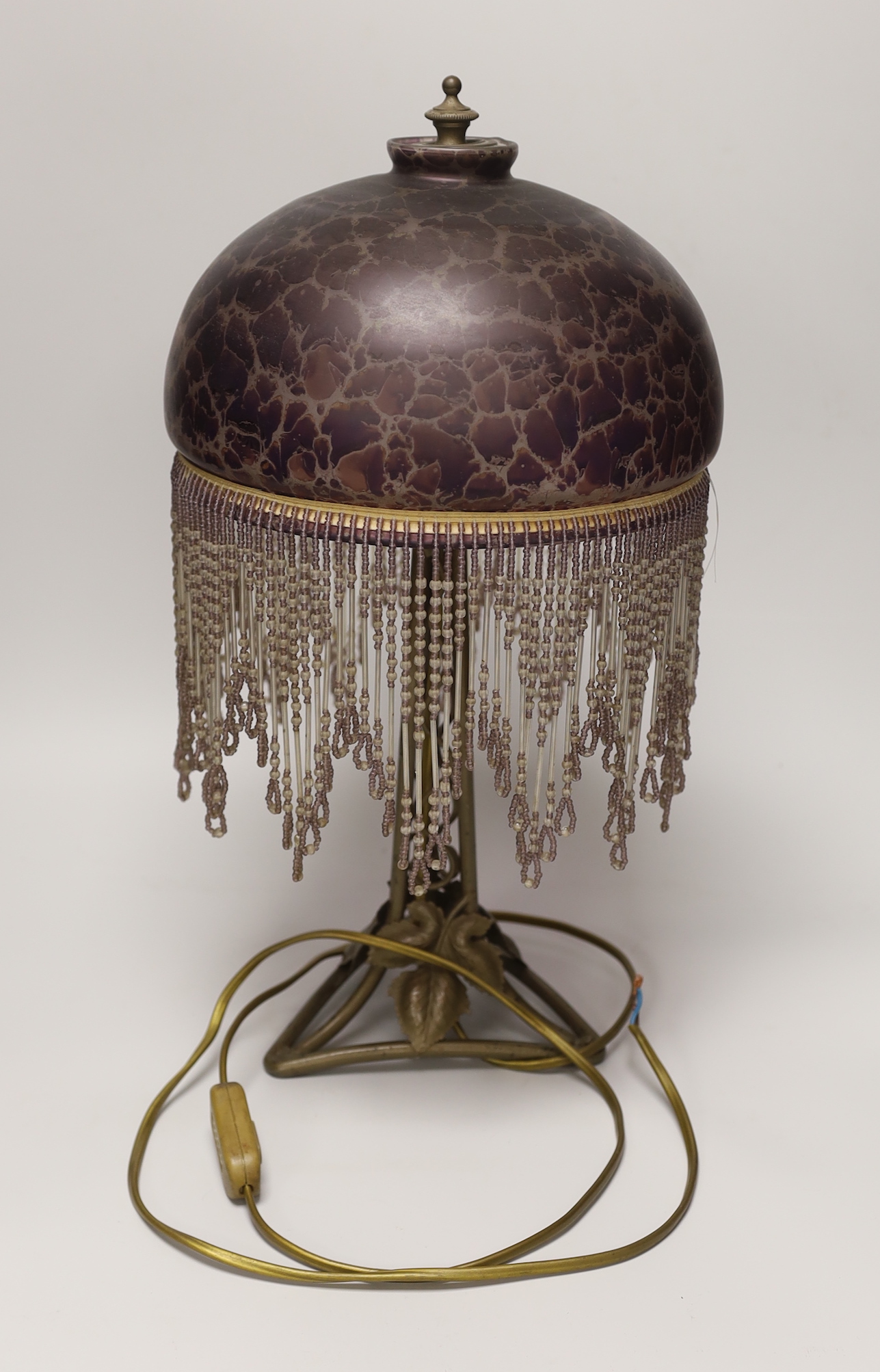 An Art Nouveau style metal lamp and glass shade with beaded fringe, 44cm high
